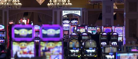 Zona de casino con varias máquinas tragamonedas y un letrero que dice 'High Limit Slots'.