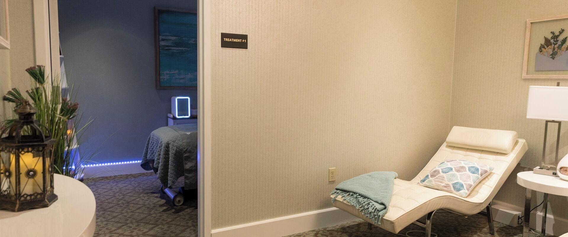 A treatment room with a massage chair, a small table with a lamp, and a sign indicating the treatment room.