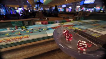 A craps table with dice and a craps layout in a casino.