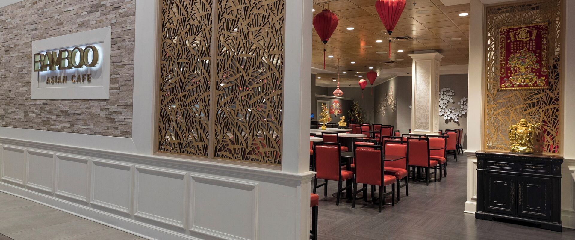 A restaurant interior with a sign reading "Bamboo Asian Cafe," red chairs, and traditional decor.