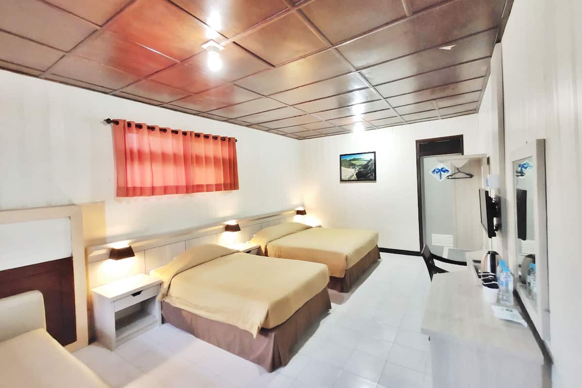 Quarto de hotel com duas camas, uma escrivaninha, um espelho e uma janela com cortina.