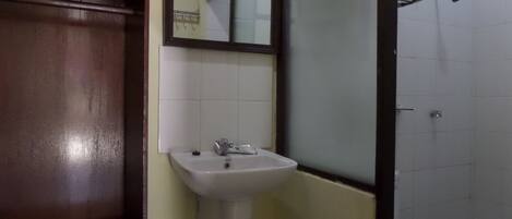 A bathroom with a sink, mirror, and toilet.