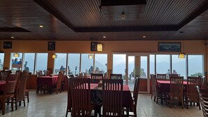 Un restaurante con muebles de madera, ventanas amplias y vistas a montañas.