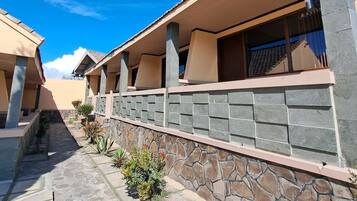 Un edificio con fachada de piedra, varios balcones y un cielo azul despejado.