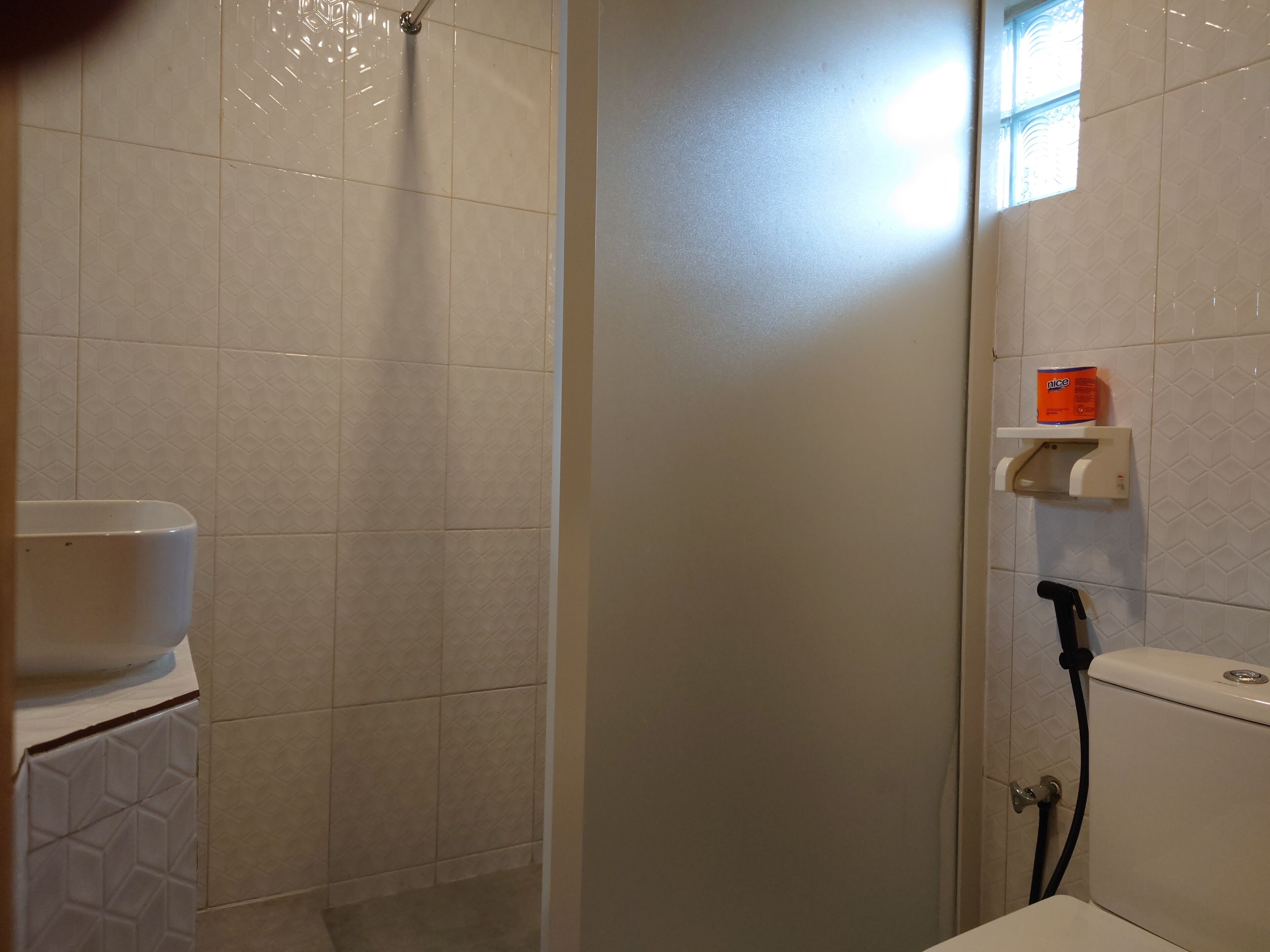 A bathroom with a shower, toilet, and a sink.