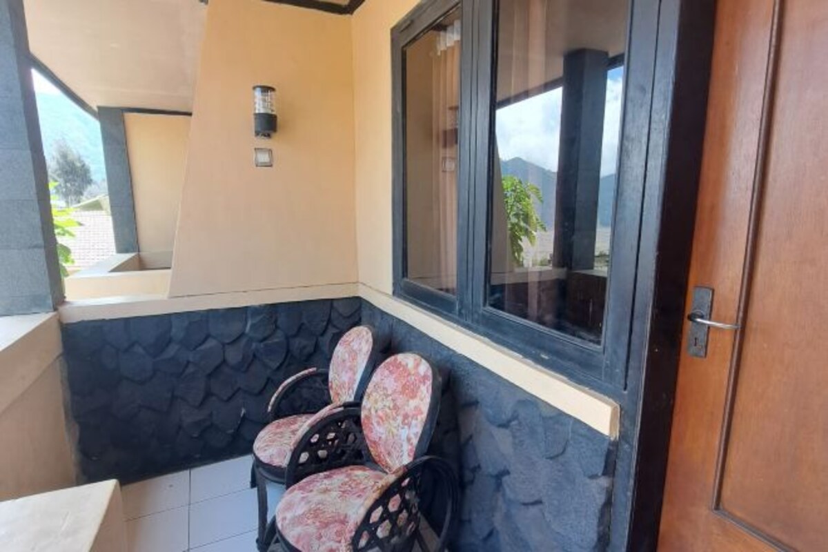 Un rincón amoblado con dos sillas, una ventana y una puerta.