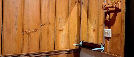 Ein Badezimmer mit Holzwandverkleidung, einem weißen Waschbecken, einem Handtuchhalter und einem Spiegel.