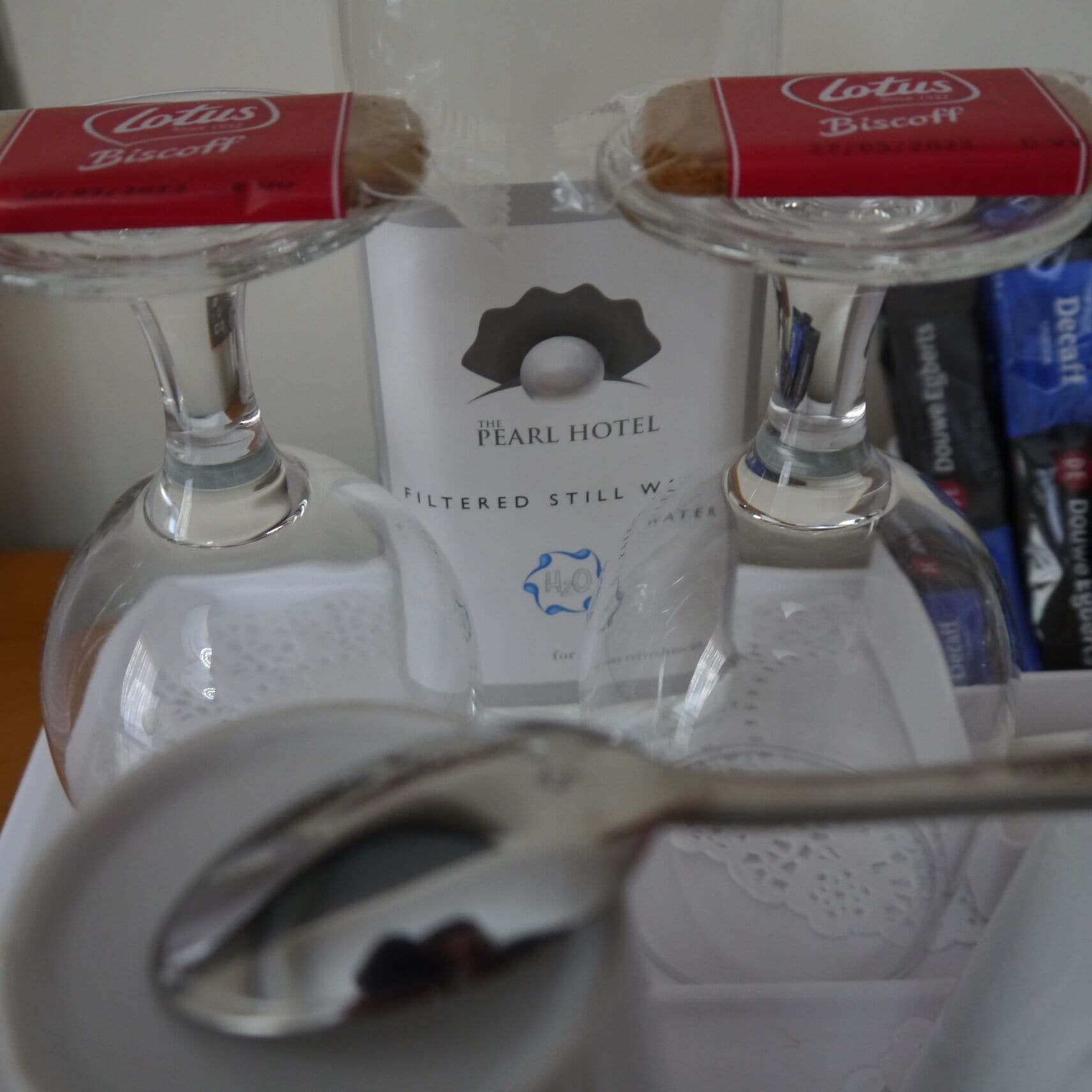 Two glass bottles with red labels, a spoon, and a white box with a logo and text.