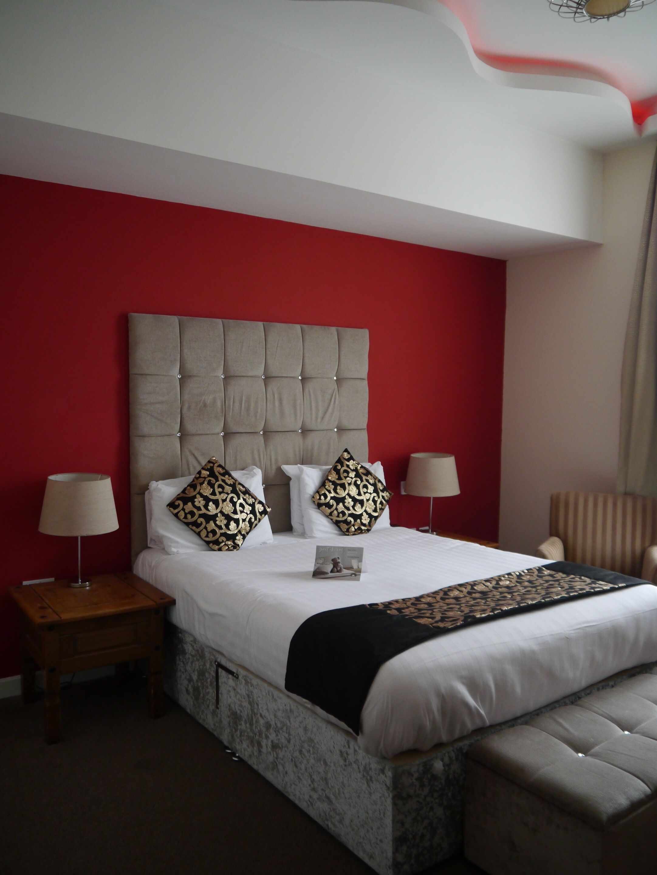 A hotel room with a large bed, two bedside tables, and a chair.