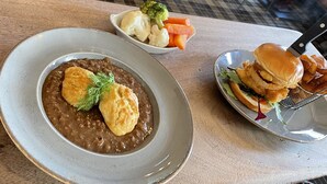 Un plato de comida con una galleta y verduras acompañantes.
