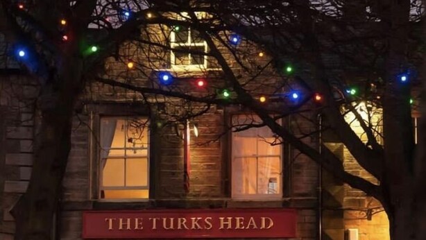 Un edificio con un letrero que dice "THE TURKS HEAD".
