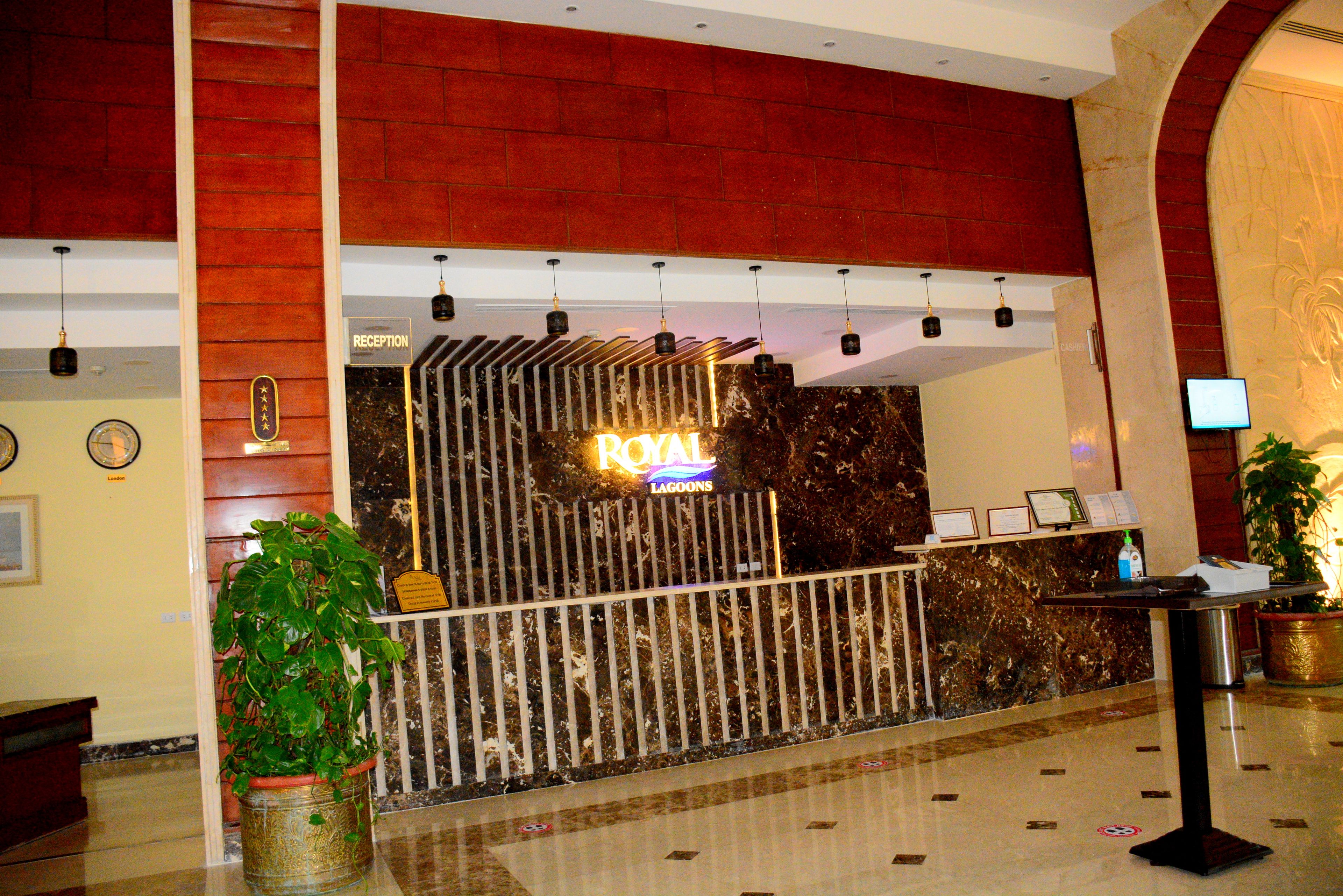 A reception area with a reception desk, a neon sign, and a plant.