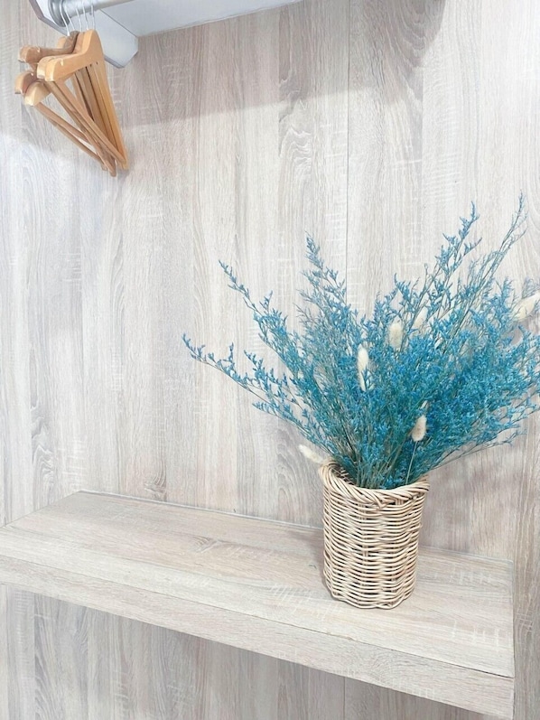 Une étagère sur laquelle repose un panier tressé contenant des feuilles bleues.