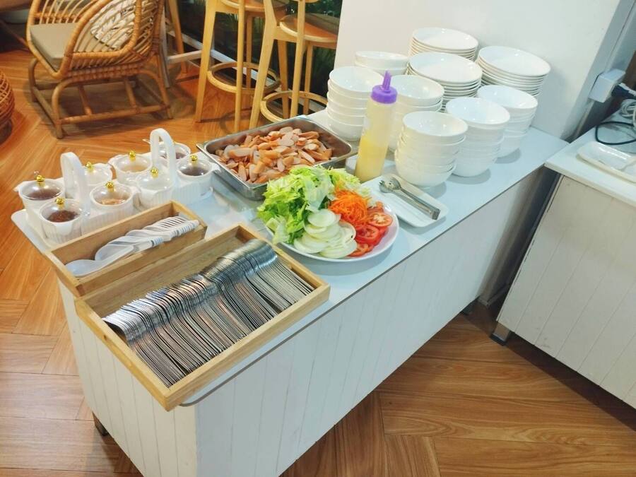 A buffet setup with various food items, plates, and condiments.