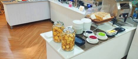 A buffet setup with various food items and condiments.