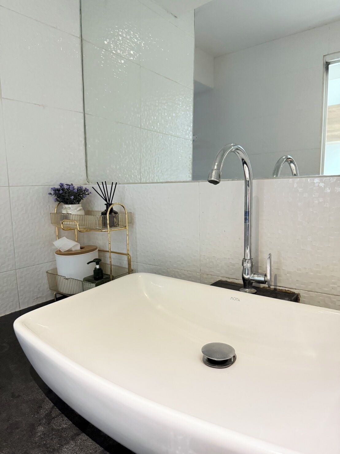 Un baño moderno con un lavamanos grande blanco, grifo cromado y un espejo encima.