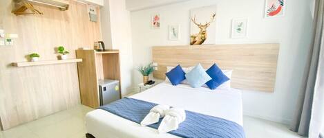 Una habitación de hotel con una cama, un escritorio y un cabecero decorado con arte.