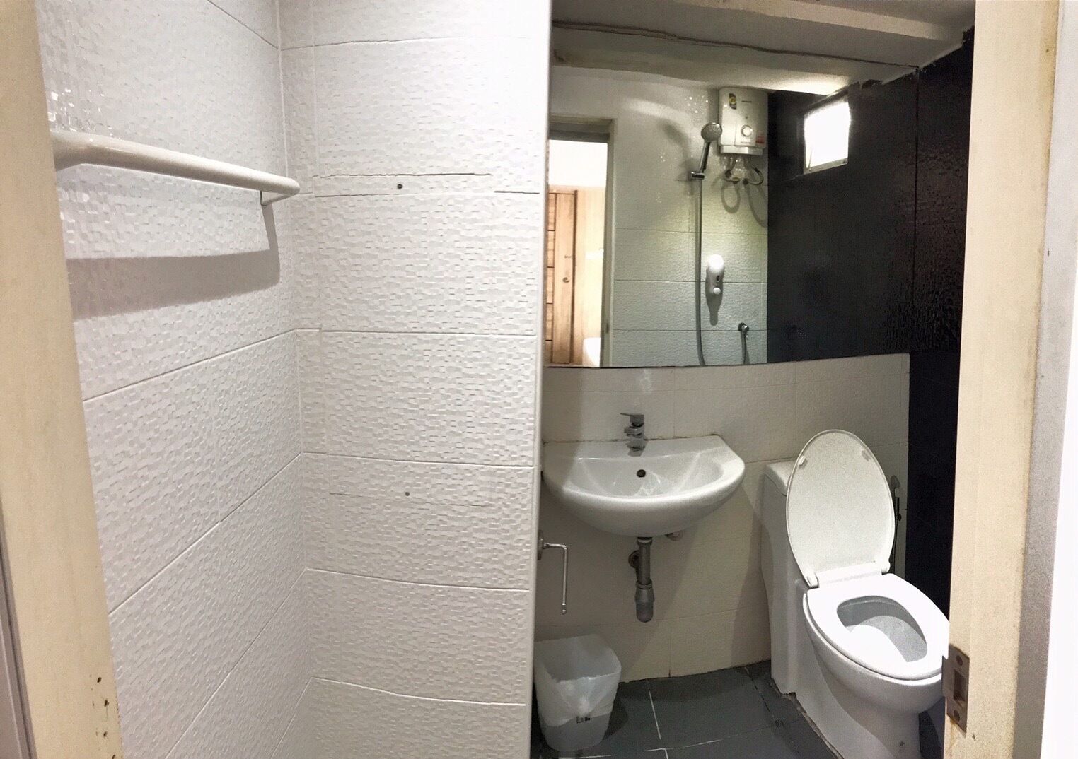 Une petite salle de bain compacte avec un lavabo blanc, des toilettes et un espace douche.