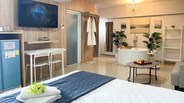 Una habitación de hotel moderna con cama, escritorio, televisor, ducha y bañera.