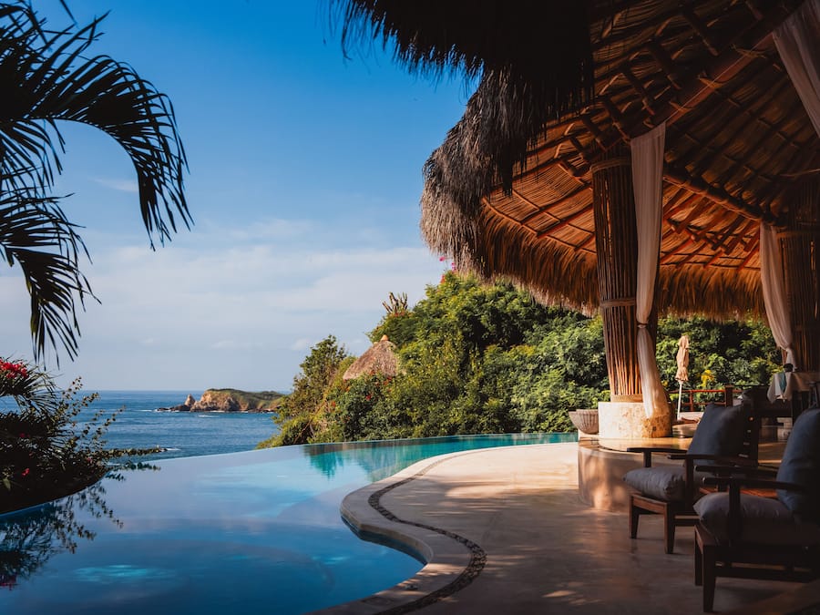 Una piscina al aire libre, sombrillas, tumbonas