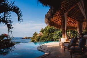 Una piscina al aire libre, sombrillas, tumbonas