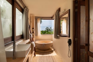 A bathroom with a bathtub, a sink, and a telephone.