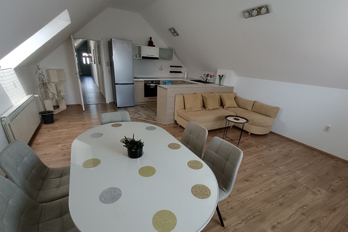 Une cuisine moderne dotée d’un four encastré et d’un coin repas avec une table ronde et des chaises.