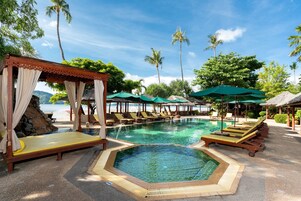 Una piscina al aire libre, sillones reclinables de piscina