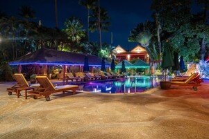 Una piscina al aire libre, sillones reclinables de piscina