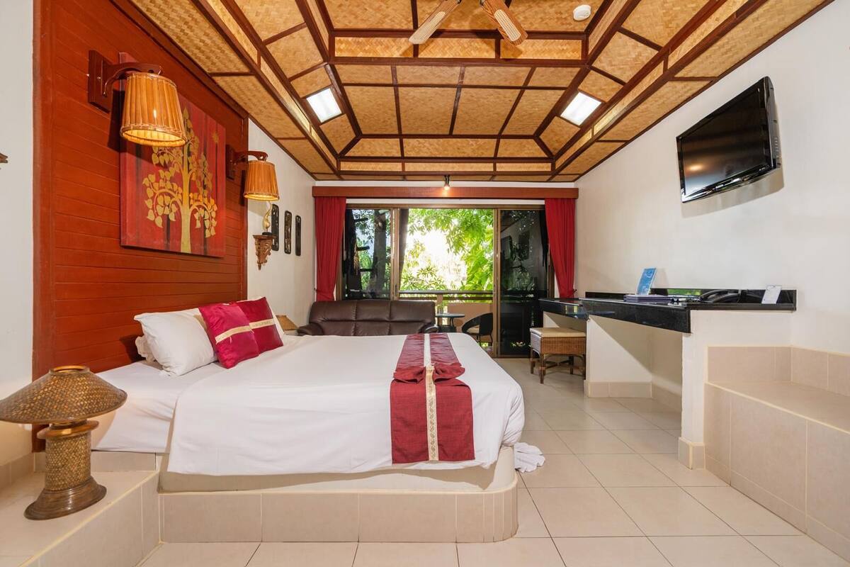 Une chambre d’hôtel avec un grand lit, un bureau et une télévision.