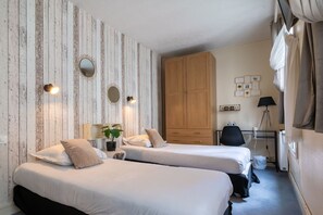 A room with two beds, a wooden wardrobe, a desk with a chair, and a lamp. - Nouvel Hôtel Paris (Paris)