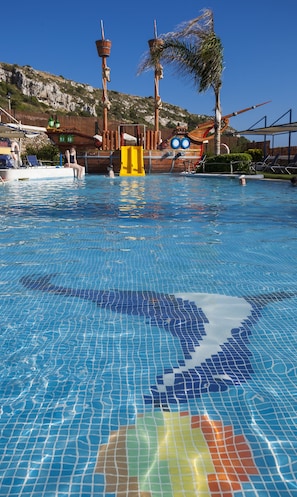 Una piscina al aire libre, tumbonas