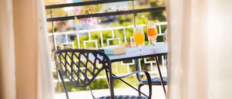 A balcony with a table, two chairs, and two drinks.
