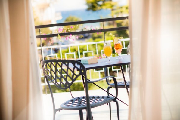 A balcony with a table, two chairs, and two drinks.