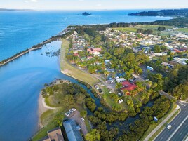 An aerial view of a coastal residential area with houses, roads, and a marina.