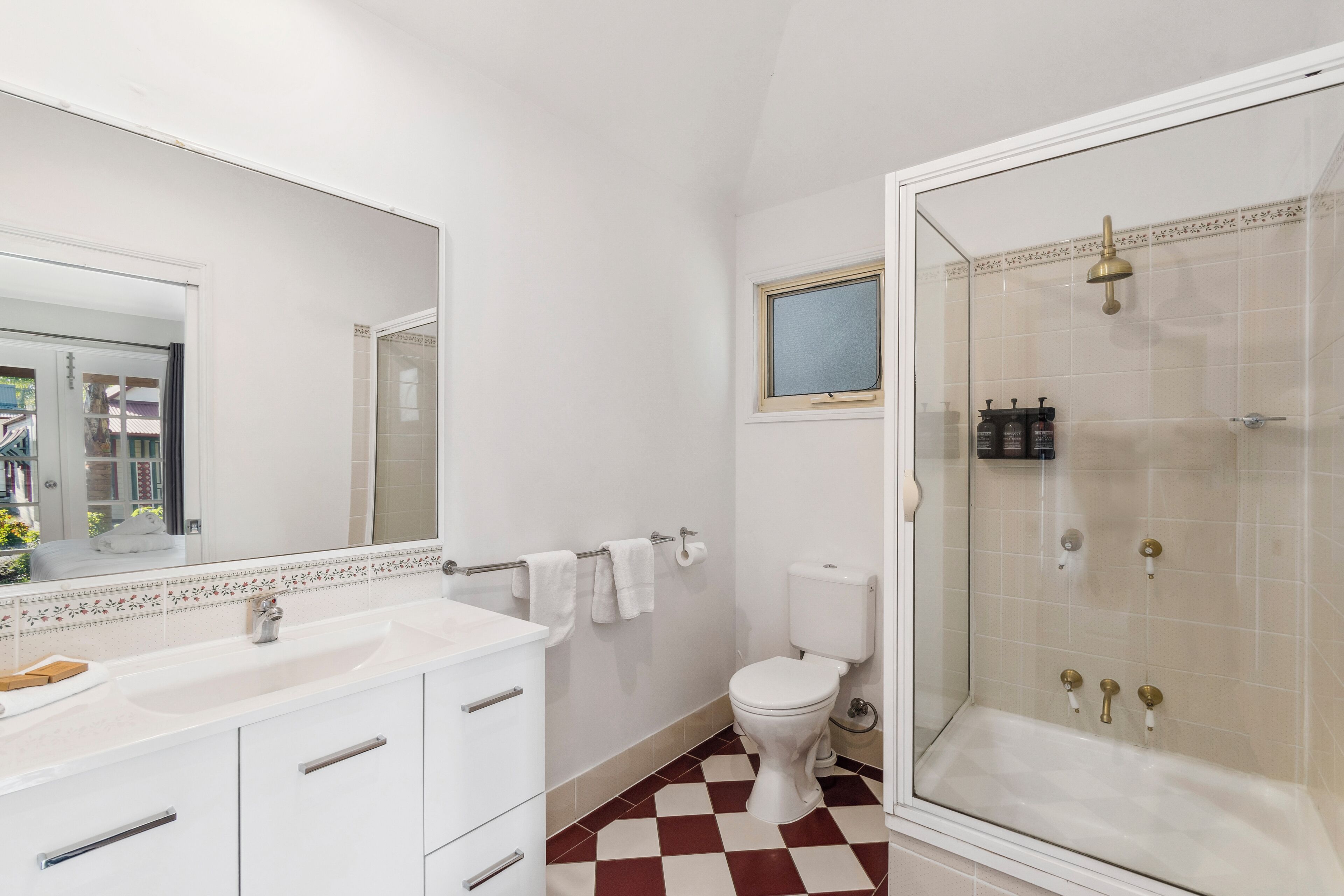 A bathroom with a white sink, toilet, and shower.