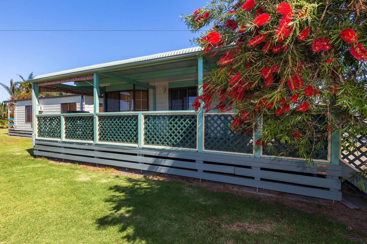 A single-story building with a covered porch and a lattice fence.