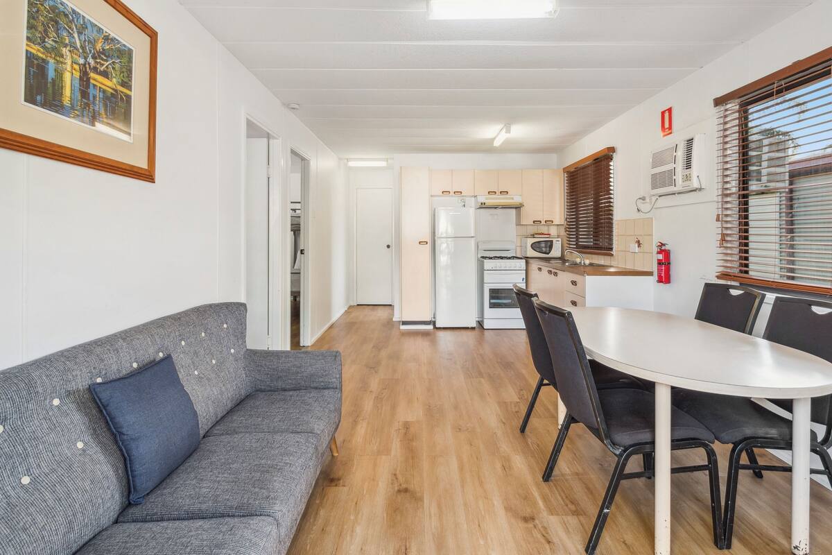 A compact living space with a kitchenette, a dining area, and a sofa.