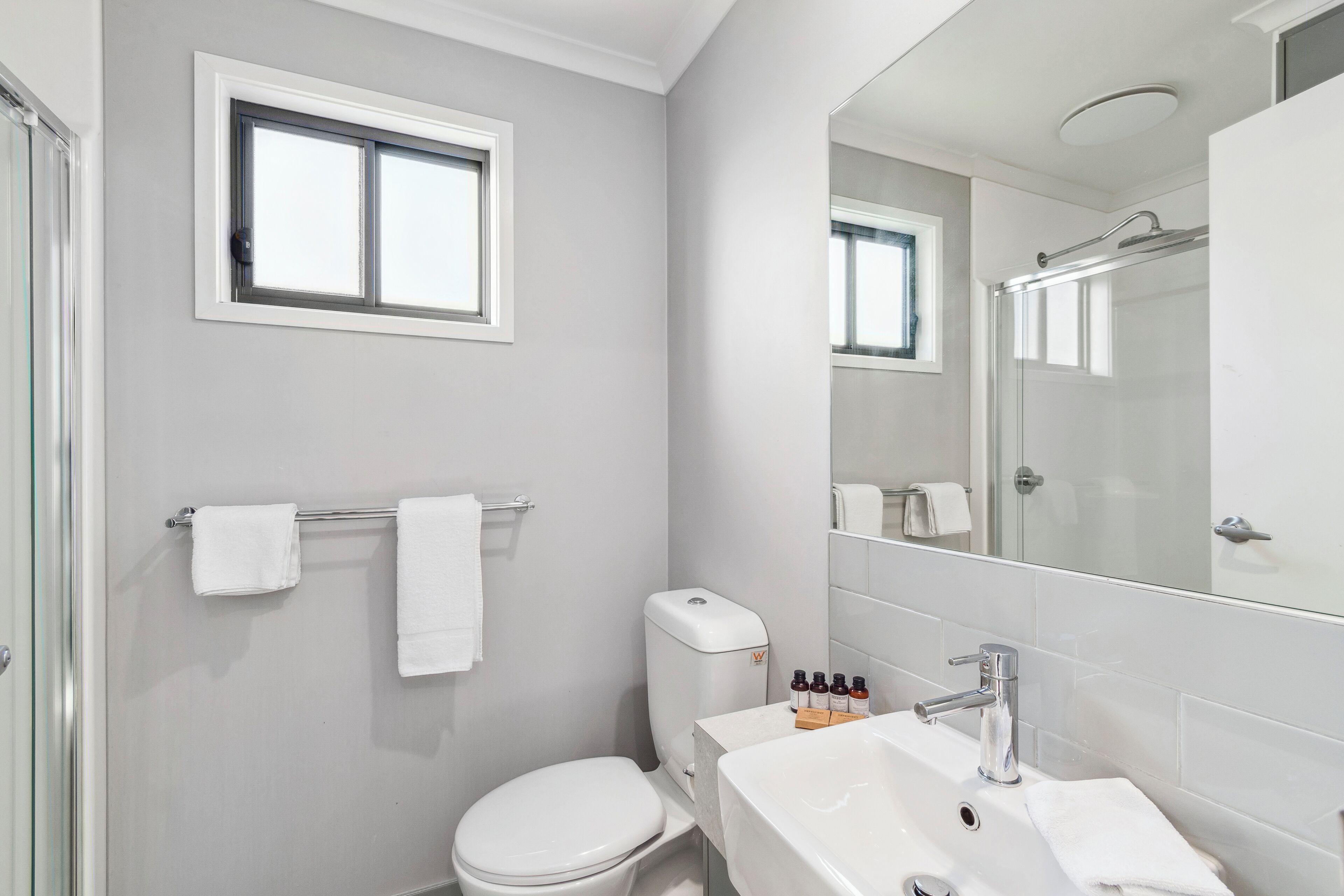 Ein Badezimmer mit Toilette, Waschbecken und Spiegel.