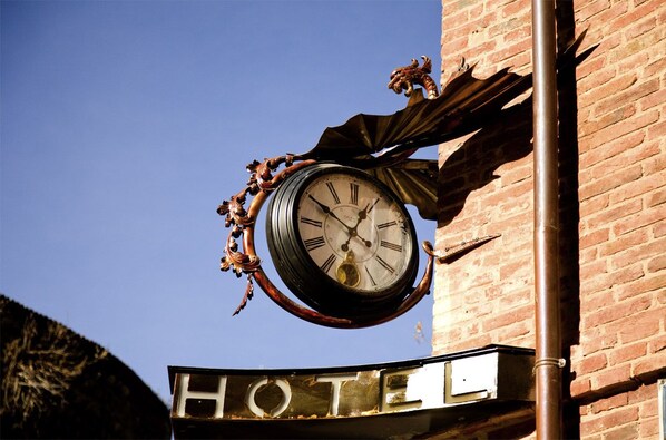 A hotel sign with a large clock and ornate metalwork. - Hotel SPA QH Centro Leon (León)
