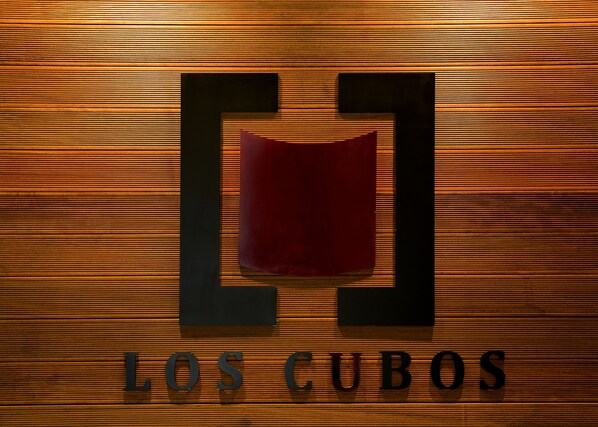 Un logotipo con las letras “L” y “C” sobre un fondo de madera, y el texto “LOS CUBOS” debajo.