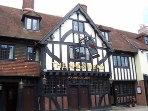 Un edificio de estilo Tudor tradicional con un letrero que dice "The Nag's Head" y "Accommodation", indicando que es un alojamiento.