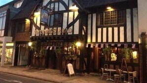 Un edificio de estilo Tudor tradicional con un letrero que dice “THE NAG’S HEAD”.