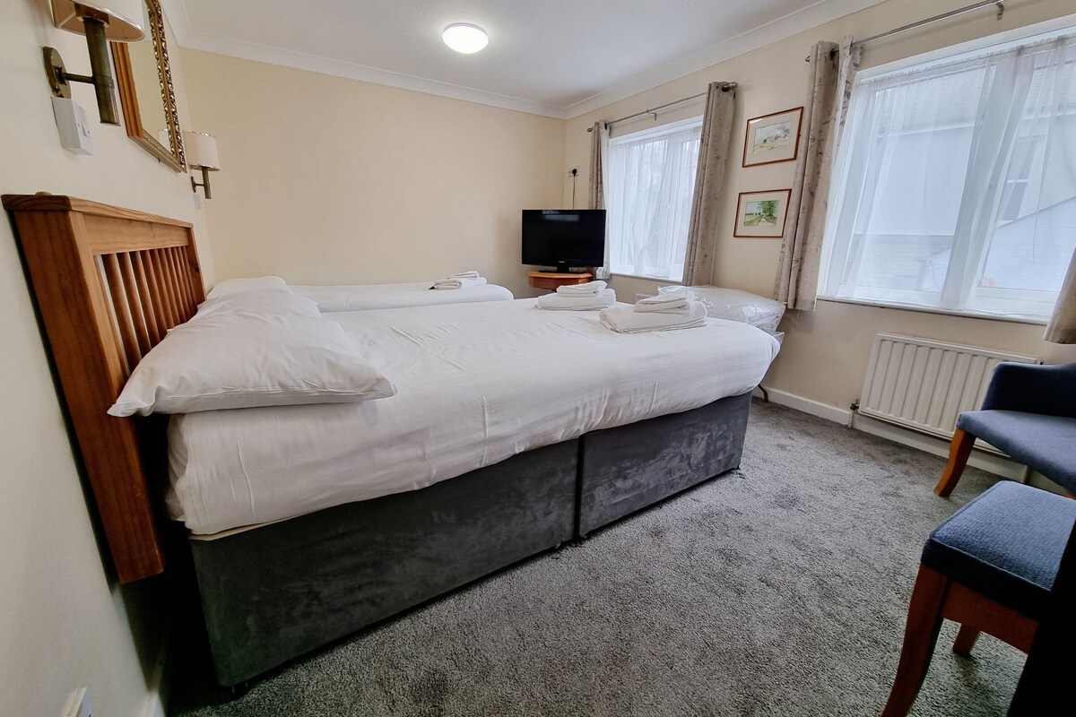 Une chambre d’hôtel avec un grand lit, une télévision et un fauteuil.