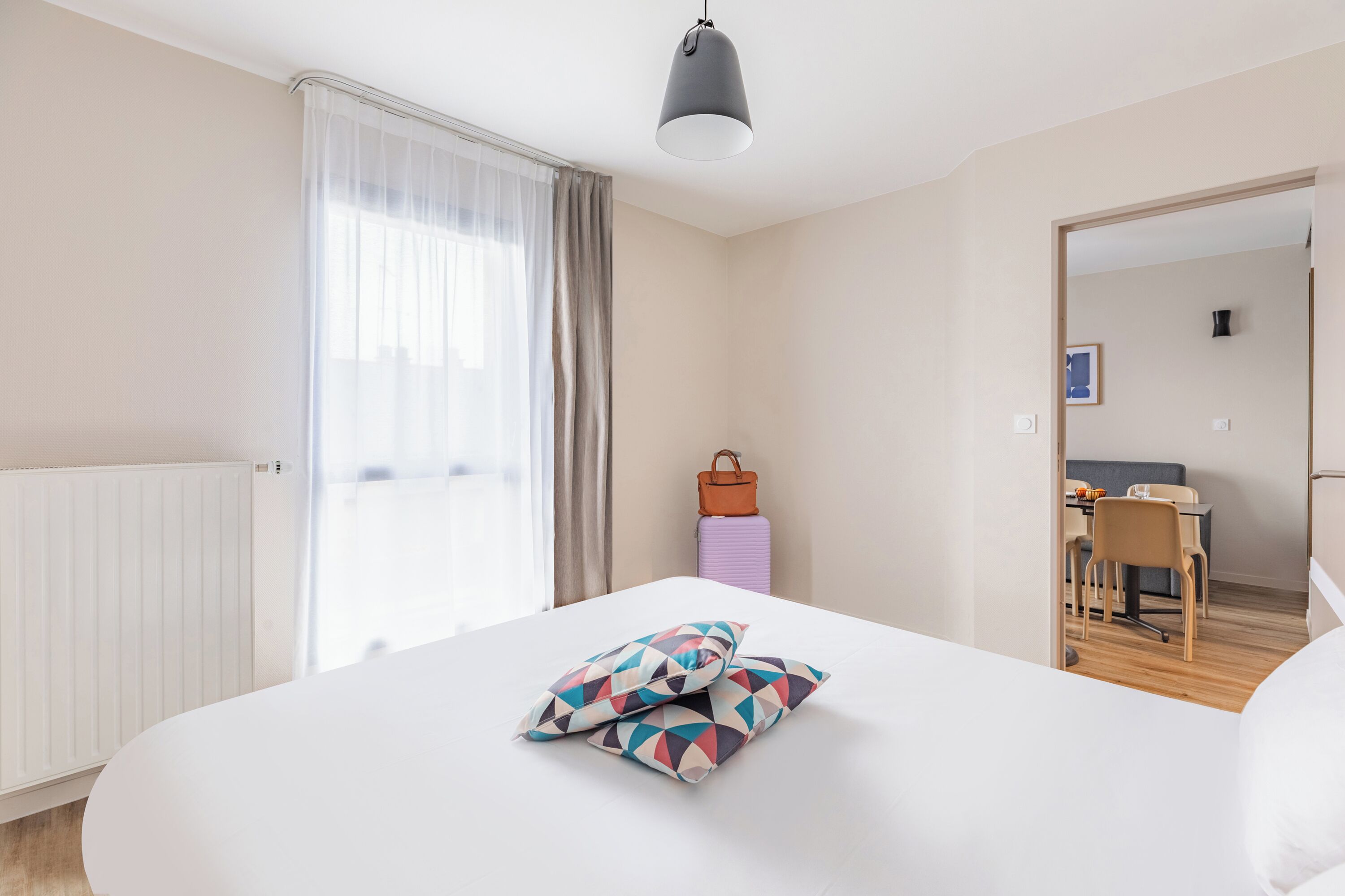 Una habitación de hotel con una cama grande, un escritorio y una silla al fondo.