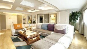 A spacious living room with a large sofa, a coffee table, and a cabinet.