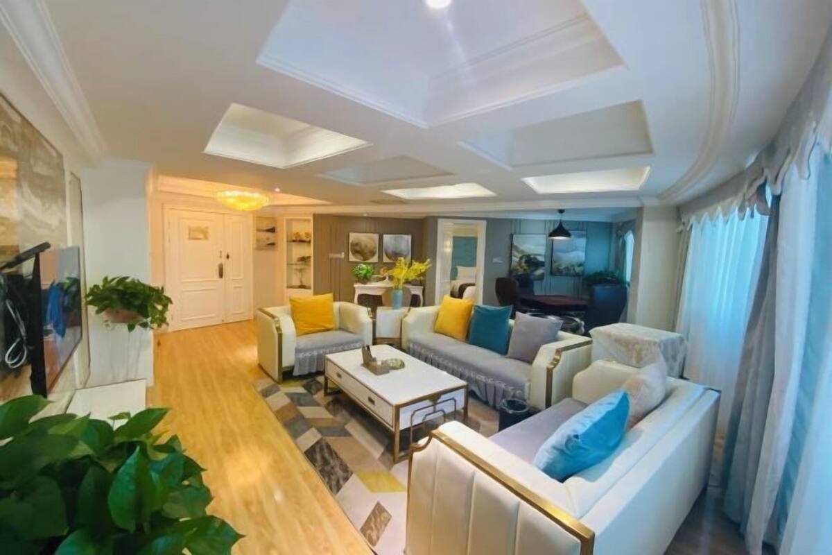 A modern living room with a sofa set, a coffee table, and a TV.