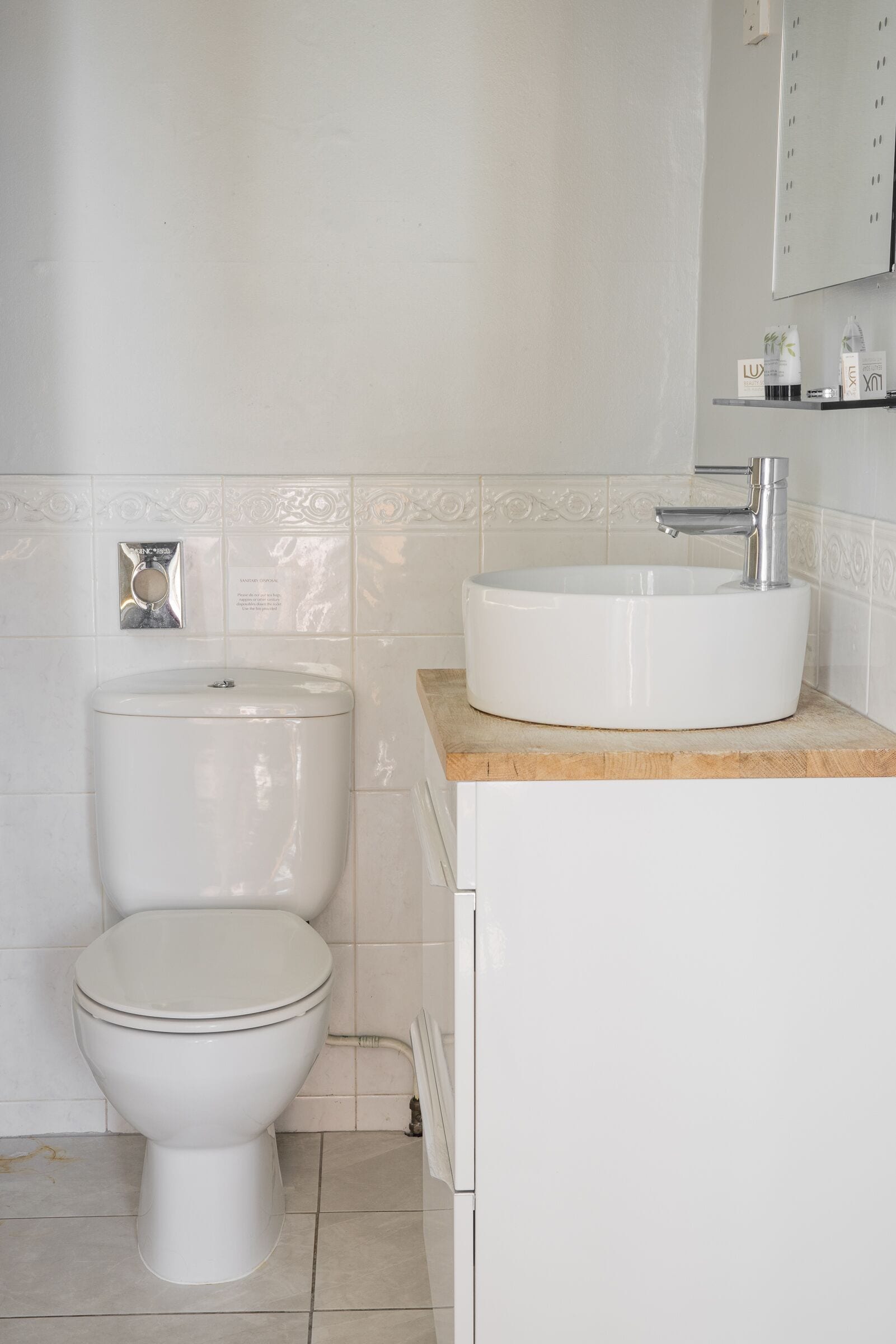 Een badkamer met toilet, wastafel en kast.