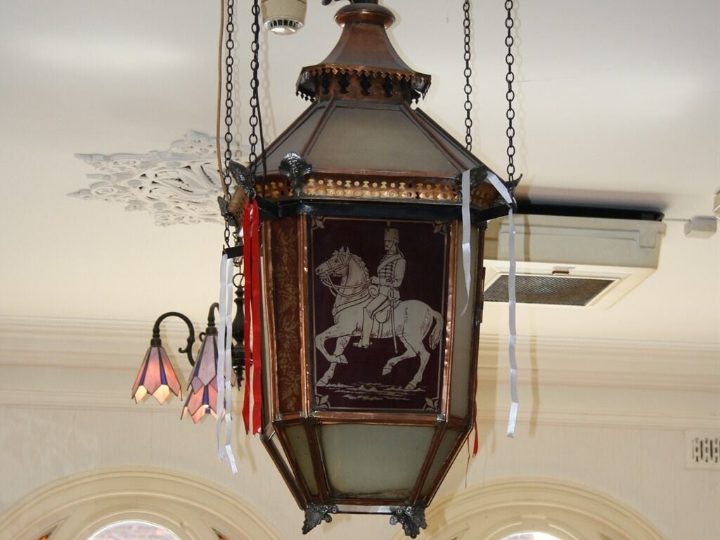 A hanging lantern with a detailed engraving of a figure on horseback.