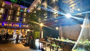 A hotel courtyard at night with outdoor seating, a water feature, and illuminated balconies. - Swiss-Belhotel Danum Palangkaraya (Palangkaraya)